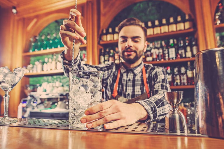 Bartender mixing a drink behind a pub bar