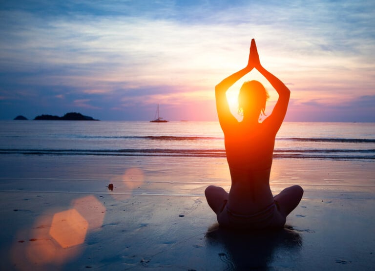 A woman is doing yoga at the beach during the holiday season