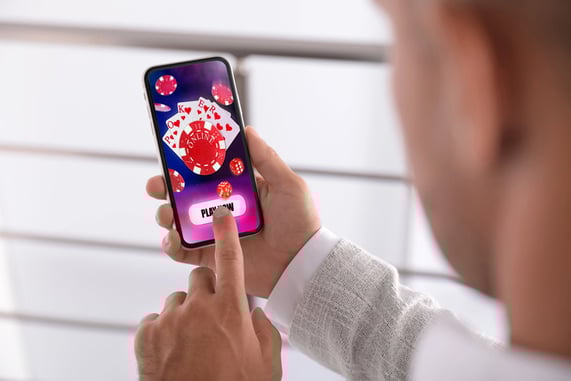 Person playing a mobile card game app on a smartphone during a casual session