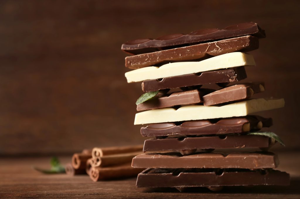 A stack of choclate bars with dark, mild, and white chocolate