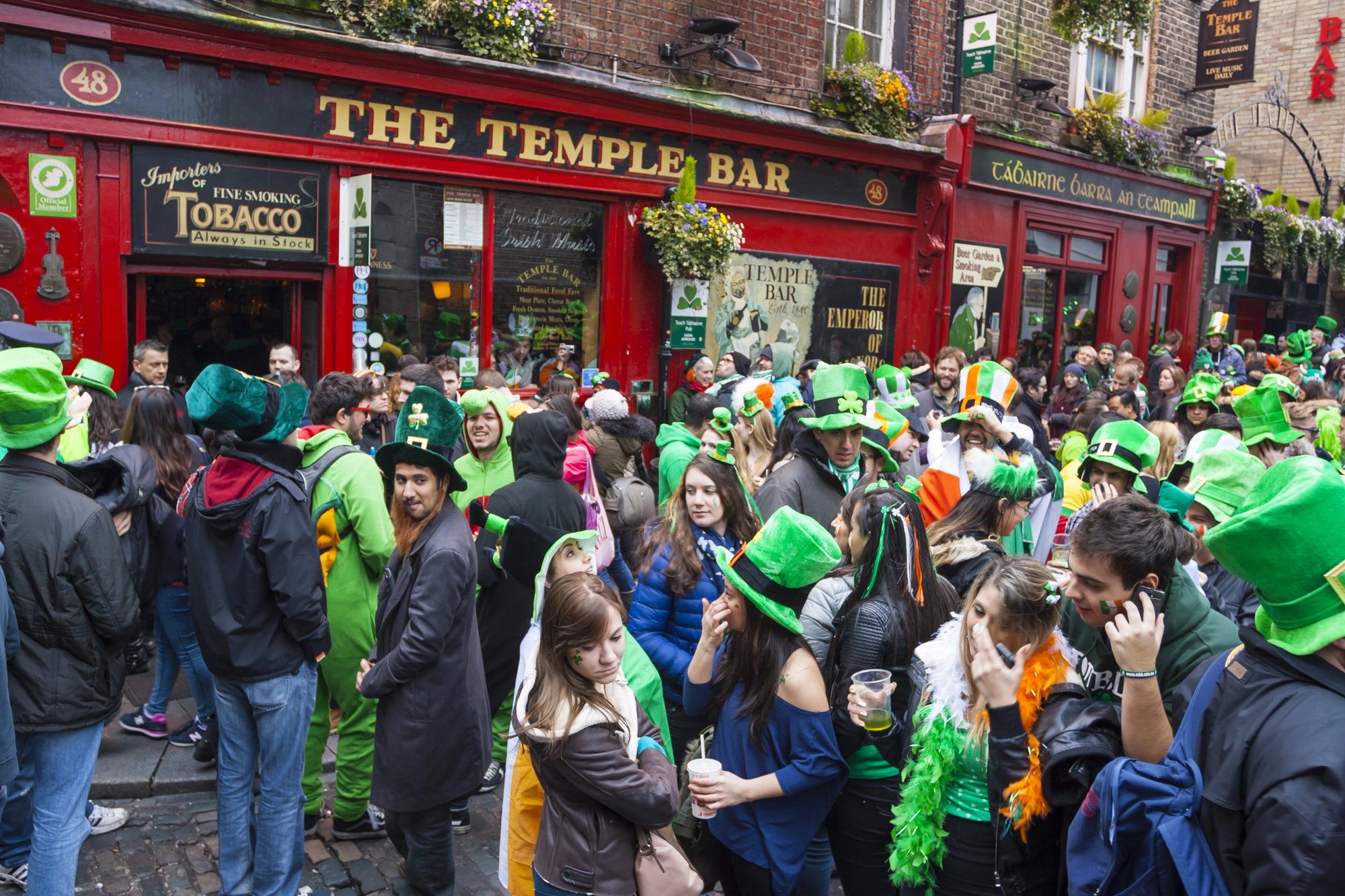People celebrating St. Patrick's Day with Irish Beer in Dublin, Ireland next to a cozy pub.